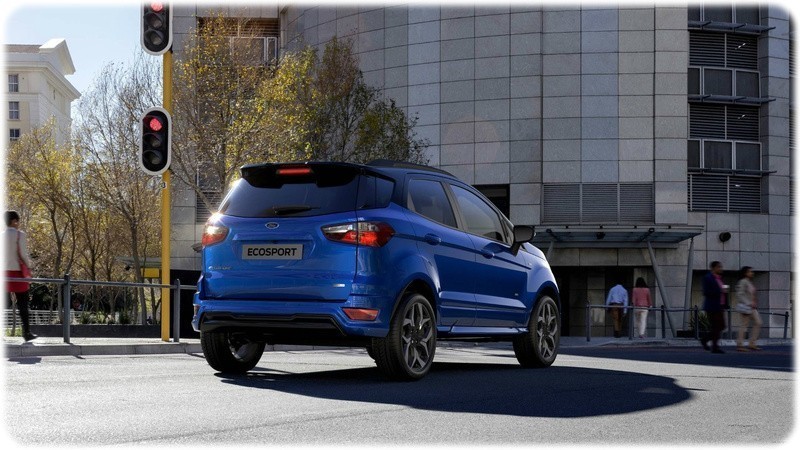 The new Ford EcoSport in deep impact blue rear facing in a town centre at the traffic lights.