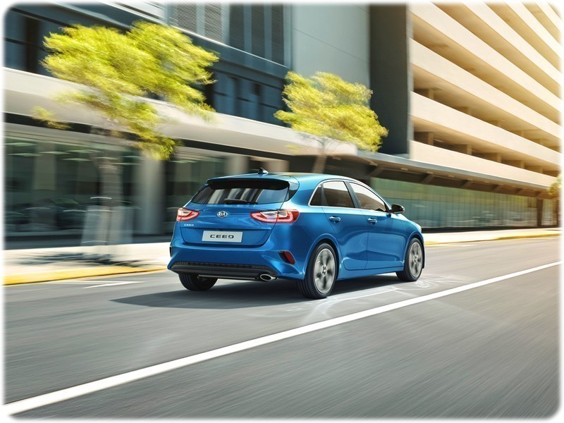 The new 2018 Kia Ceed driving through a city, rear view