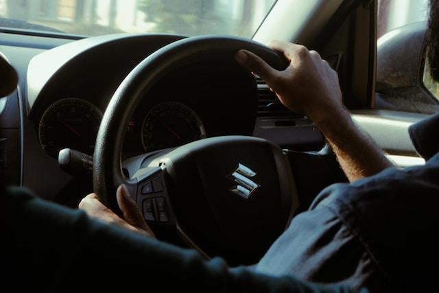 Image of a Suzuki Steering Wheel with Hands on.